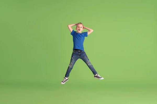 Boldog fiú játszik és szórakozás zöld stúdió háttér, érzelmek — Stock Fotó