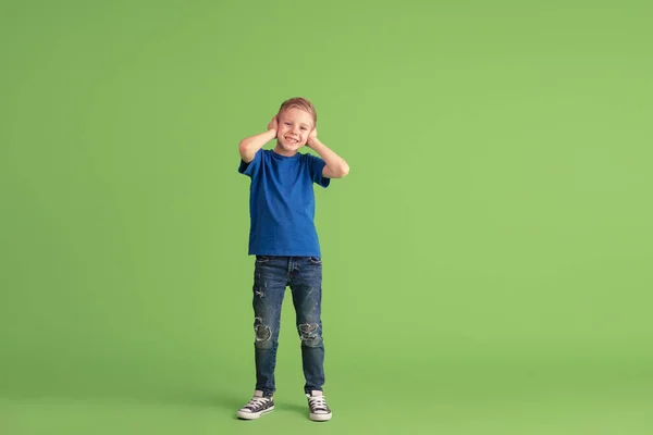 Glad pojke spela och ha kul på grön studio bakgrund, känslor — Stockfoto