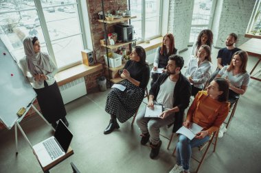 Bayan Müslüman konuşmacı üniversite atölyesinde sunum yapıyor.