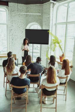 Kadın Afro-Amerikan konuşmacı üniversite atölyesinde sunum yapıyor.