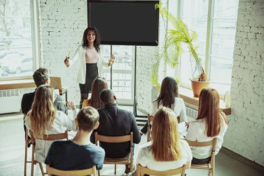 Kadın Afro-Amerikan konuşmacı üniversite atölyesinde sunum yapıyor.