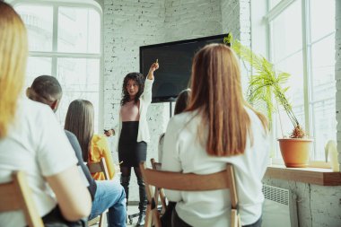 Kadın Afro-Amerikan konuşmacı üniversite atölyesinde sunum yapıyor.
