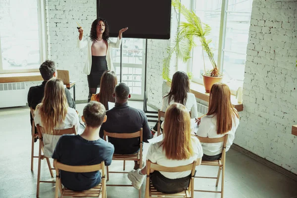 Kadın Afro-Amerikan konuşmacı üniversite atölyesinde sunum yapıyor.