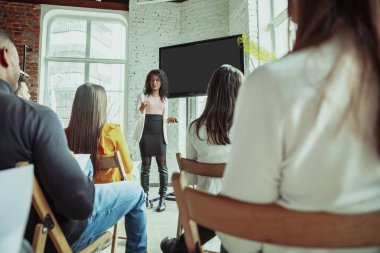 Kadın Afro-Amerikan konuşmacı üniversite atölyesinde sunum yapıyor.