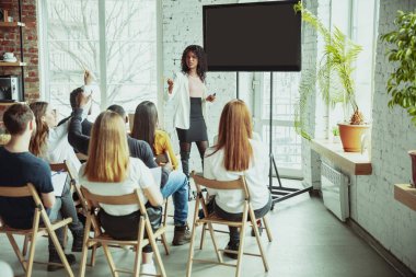 Kadın Afro-Amerikan konuşmacı üniversite atölyesinde sunum yapıyor.