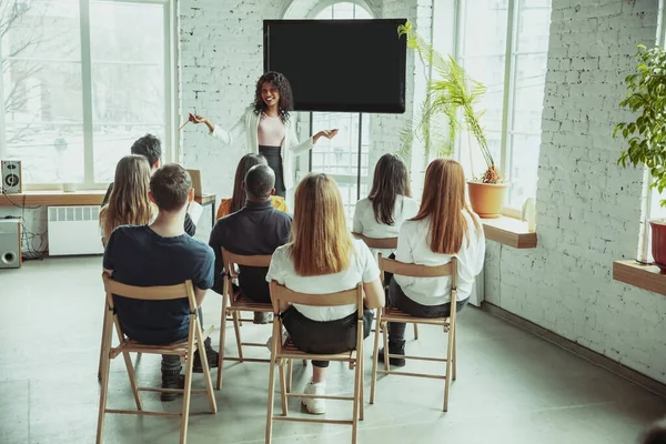 Female african-american speaker giving presentation in hall at university workshop — Stock Photo, Image