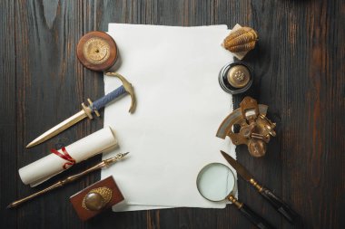 Eski moda daire, harflerle kaplıydı. Koyu ahşap arka plana aksesuarlar yazıyordu.
