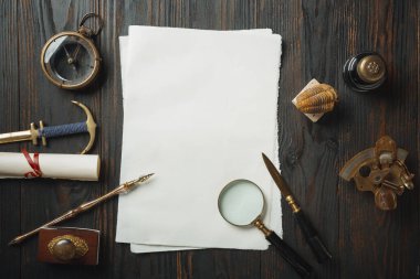 Eski moda daire, harflerle kaplıydı. Koyu ahşap arka plana aksesuarlar yazıyordu.