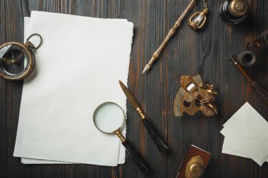 Eski moda daire, harflerle kaplıydı. Koyu ahşap arka plana aksesuarlar yazıyordu.