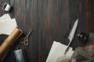 Eski moda daire, harflerle kaplıydı. Koyu ahşap arka plana aksesuarlar yazıyordu.