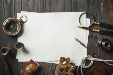 Eski moda daire, harflerle kaplıydı. Koyu ahşap arka plana aksesuarlar yazıyordu.