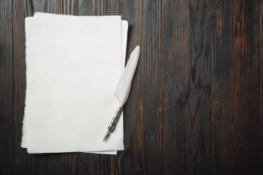 Eski moda daire, harflerle kaplıydı. Koyu ahşap arka plana aksesuarlar yazıyordu.