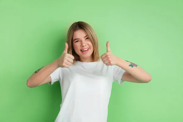 Kaukasische junge Frauen Porträt auf grünem Studiohintergrund — Stockfoto