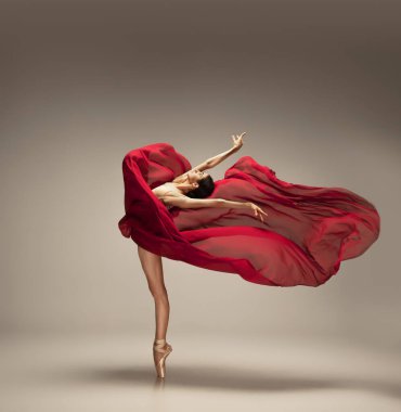 Gri stüdyo arka planında zarif bir balerin.