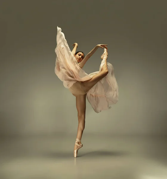 Młoda, pełna wdzięku balerina na szarym tle studia — Zdjęcie stockowe