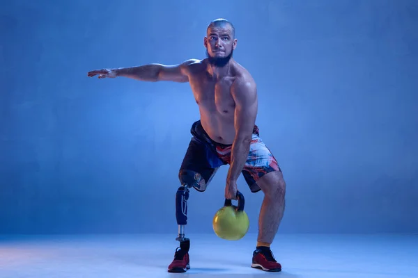 Atleta amputado discapacitado aislado en fondo azul estudio — Foto de Stock