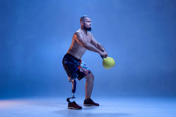 Atleta amputado discapacitado aislado en fondo azul estudio — Foto de Stock