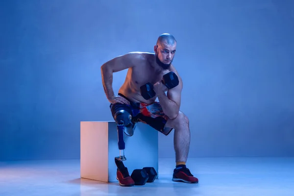 Atleta amputado discapacitado aislado en fondo azul estudio — Foto de Stock