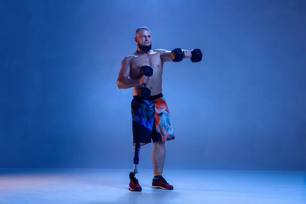 Atleta amputado discapacitado aislado en fondo azul estudio — Foto de Stock