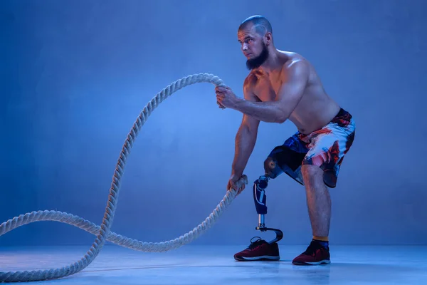 Atleta amputado discapacitado aislado en fondo azul estudio — Foto de Stock