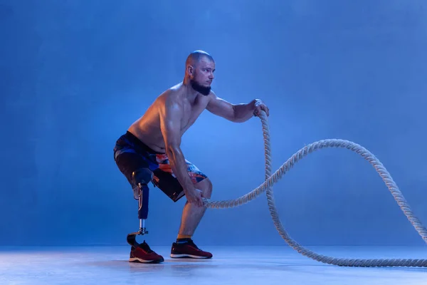Atleet gehandicapt geamputeerd geïsoleerd op blauwe studio achtergrond — Stockfoto