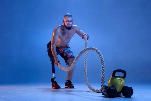 Atleta amputado discapacitado aislado en fondo azul estudio — Foto de Stock