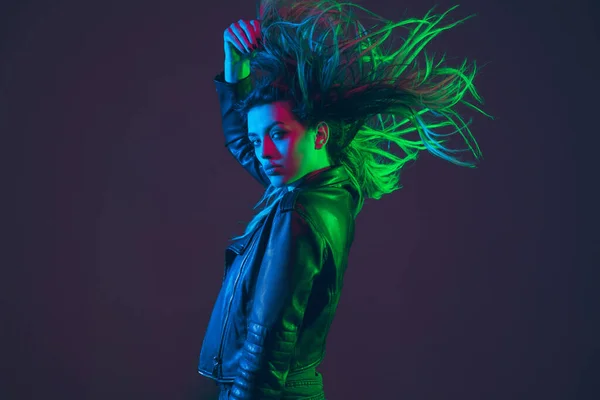 Piękny portret kobiet z dmuchanie włosy na ciemnym tle studio w kolorowe neonowe światło — Zdjęcie stockowe