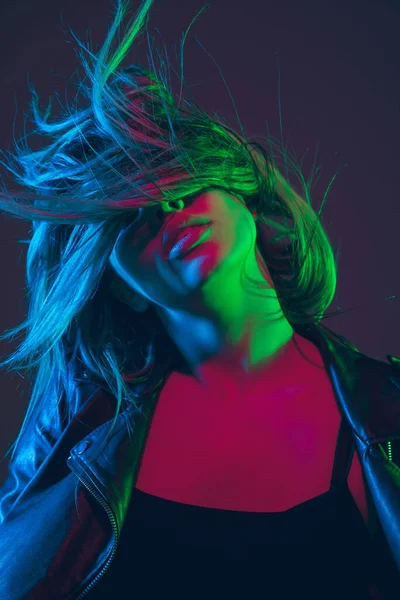 Retrato de mulheres bonitas com cabelo soprando no fundo escuro estúdio em luz de néon colorido — Fotografia de Stock