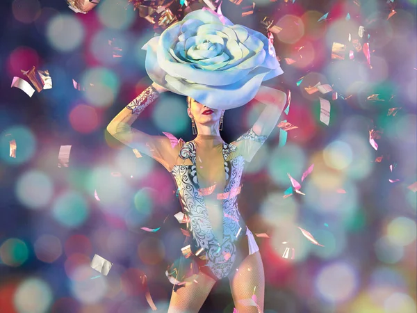 Νεαρή χορεύτρια με τεράστιο floral καπέλο σε νέον φως σε κλίση φόντο σε ιπτάμενα κομφετί — Φωτογραφία Αρχείου
