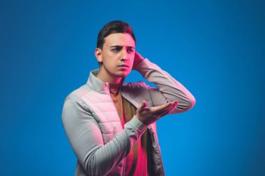 Beyaz adam portresi mavi stüdyo arka planında neon ışıkta izole edilmiş.