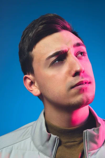 Közelkép kaukázusi férfi portré elszigetelt kék stúdió háttér neon fény — Stock Fotó
