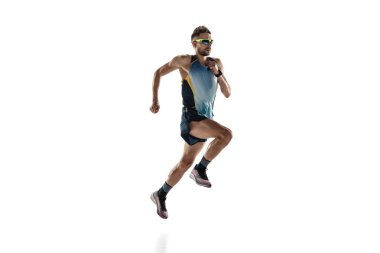 Beyaz stüdyo arka planında tek başına koşan triatlon erkek sporcusu