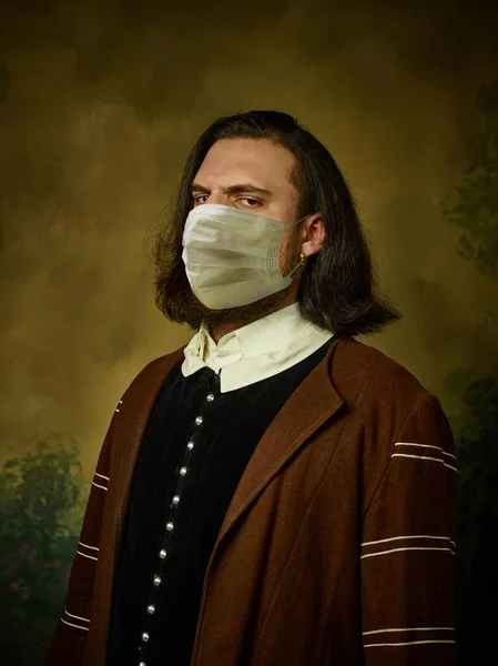 若いです男として中世の騎士暗い背景に身に着けている保護マスクに対するコロナウイルス — ストック写真