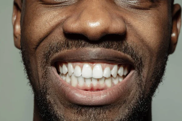 Крупным планом лица красивого африканско-американского молодого человека, сфокусированного на рту — стоковое фото