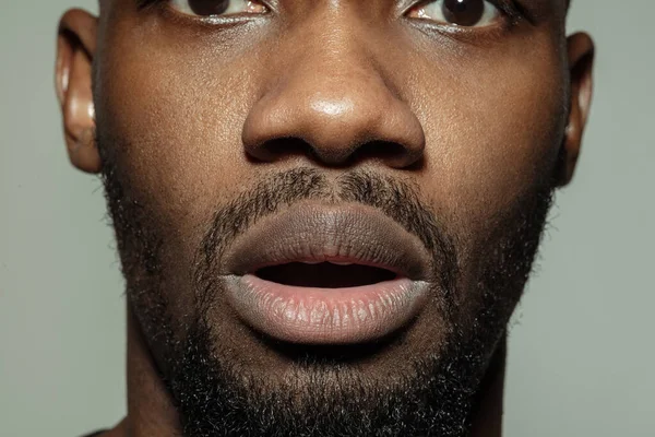 Крупным планом лица красивого африканско-американского молодого человека, сфокусированного на рту — стоковое фото