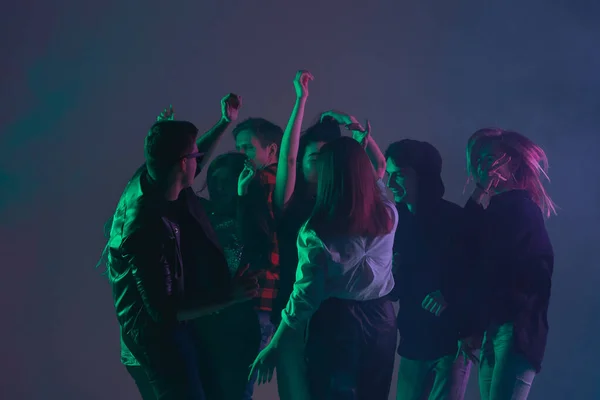 Animadora fiesta de baile, concepto de actuación. Multitud de personas bailando con luces de neón levantaron las manos — Foto de Stock