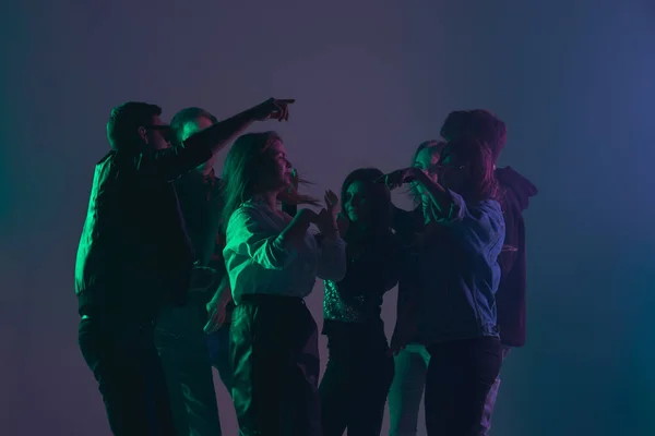 Pesta dansa sorak-sorai, konsep pertunjukan. Bayangan kerumunan orang menari dengan lampu neon mengangkat tangan — Stok Foto