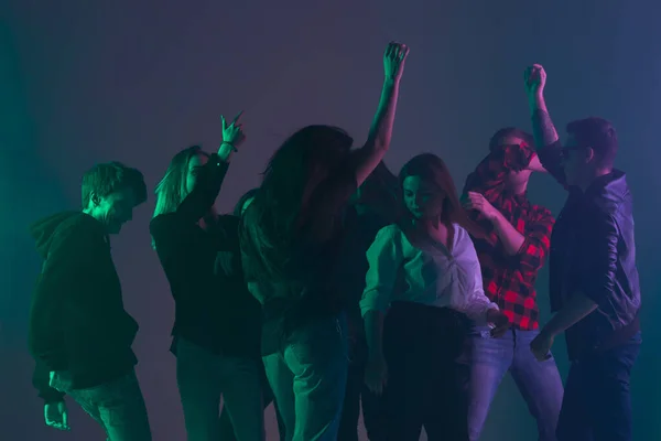 Festa de dança de torcida, conceito de desempenho. Sombra de multidão de pessoas dançando com luzes de néon levantadas mãos para cima — Fotografia de Stock