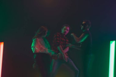 Amigo dansı partisi, performans konsepti. Neon ışıklarıyla dans eden kalabalığın gölgesi ellerini kaldırdı.