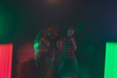 Amigo dansı partisi, performans konsepti. Neon ışıklarıyla dans eden kalabalığın gölgesi ellerini kaldırdı.