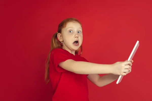 Vit liten flicka porträtt isolerad på röd studio bakgrund, känslor koncept — Stockfoto