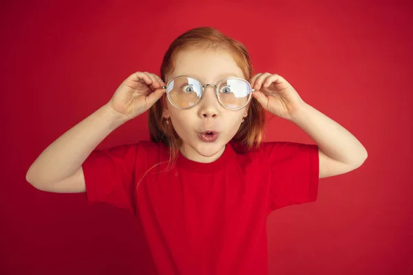 Portrait de petite fille caucasienne isolé sur fond de studio rouge, concept d'émotions — Photo