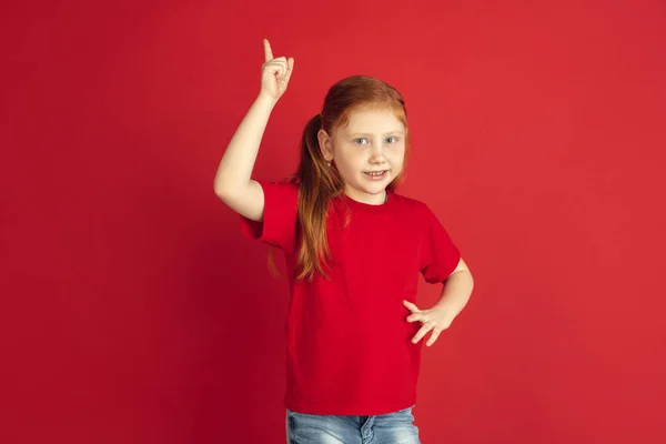 Vit liten flicka porträtt isolerad på röd studio bakgrund, känslor koncept — Stockfoto