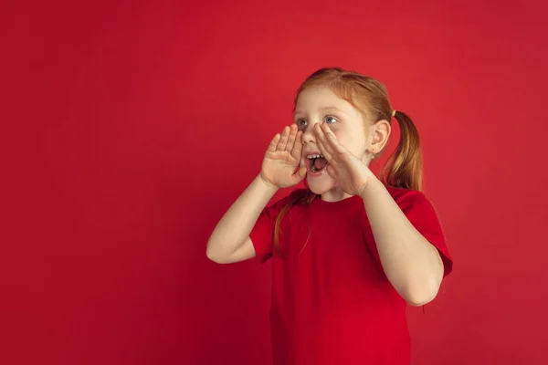 Vit liten flicka porträtt isolerad på röd studio bakgrund, känslor koncept — Stockfoto