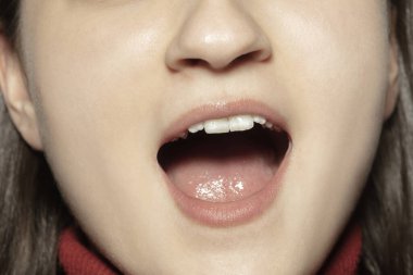 Yakın plan kadın ağzı ve doğal çıplak dudak makyajı. Kozmetoloji, dişçilik ve güzellik hizmetleri, duygular