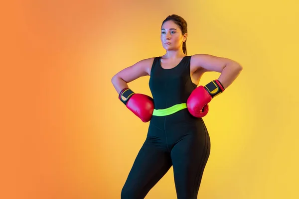 Jovem caucasiano plus size modelos femininos de treinamento em gradiente fundo laranja — Fotografia de Stock