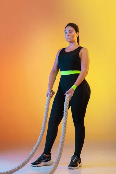 Junge kaukasische Plus-Size-Models beim Training auf orangefarbenem Hintergrund — Stockfoto