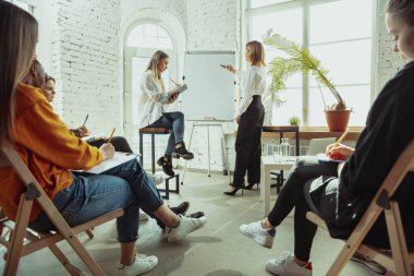 Beyaz kadın konuşmacı üniversite veya iş merkezi atölyesinde sunum yapıyor