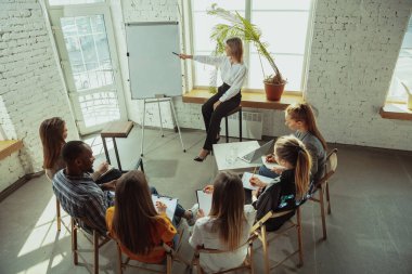 Beyaz kadın konuşmacı üniversite veya iş merkezi atölyesinde sunum yapıyor