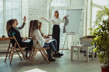 Beyaz kadın konuşmacı üniversite veya iş merkezi atölyesinde sunum yapıyor